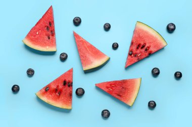Mavi arka planda taze karpuz ve yaban mersini parçaları
