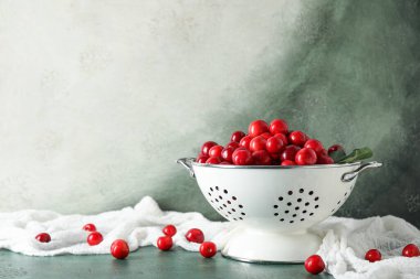 Yeşil masada kirazlı Colander.