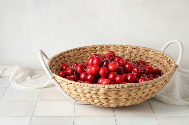 Beyaz fayans masasında vişneli sepet.