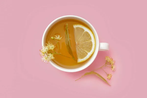 ピンクの背景にレモンとリンデン茶のカップ — ストック写真