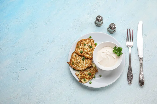 stock image Plate of tasty zucchini fritters with sour cream on light background