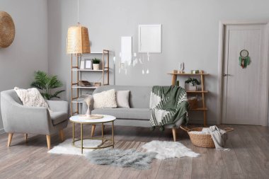 Kapısında ve tavanında kanepe, koltuk ve düş kapanı asılı modern oturma odası.