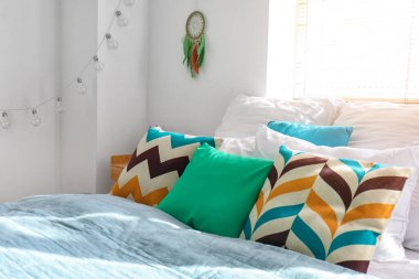 Beyaz duvarda yatak ve düş kapanı asılı modern yatak odası.