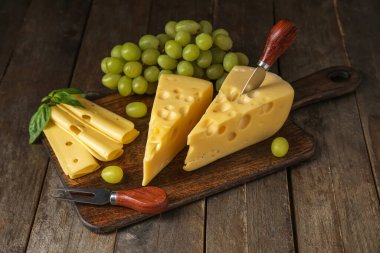 Lezzetli İsviçre peyniri ve ahşap arka planda üzümlü tahta.