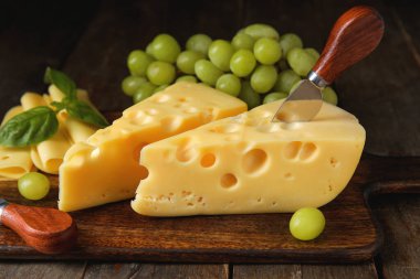 Lezzetli İsviçre peyniri ve ahşap arka planda üzümlü tahta.