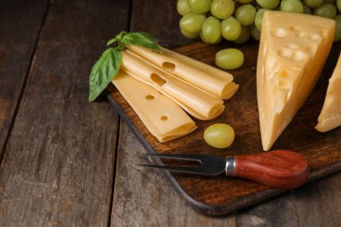 Lezzetli İsviçre peyniri ve ahşap arka planda üzümlü tahta.