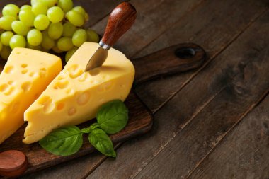 Lezzetli İsviçre peyniri ve ahşap arka planda üzümlü tahta.