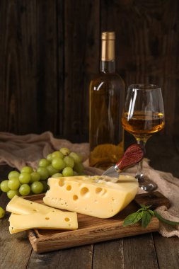 Lezzetli İsviçre peyniri ve ahşap arka planda üzümlü tahta.