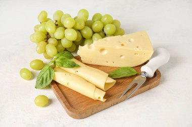 Lezzetli İsviçre peyniri ve hafif arka planda üzümlü ahşap tahta.