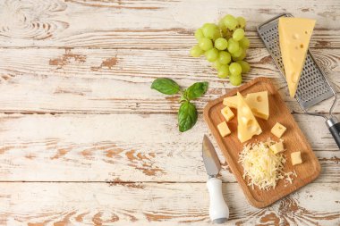 Lezzetli İsviçre peyniri ve hafif ahşap arka planda üzümlü tahta.