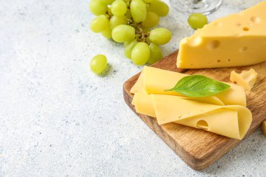 Hafif arka planda lezzetli İsviçre peyniri olan ahşap tahta.