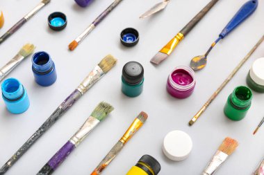 Beyaz arka planda boya, fırça ve boya bıçaklarıyla kompozisyon