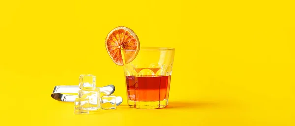 Glas Leckerer Cocktail Mit Eiswürfeln Auf Gelbem Hintergrund — Stockfoto