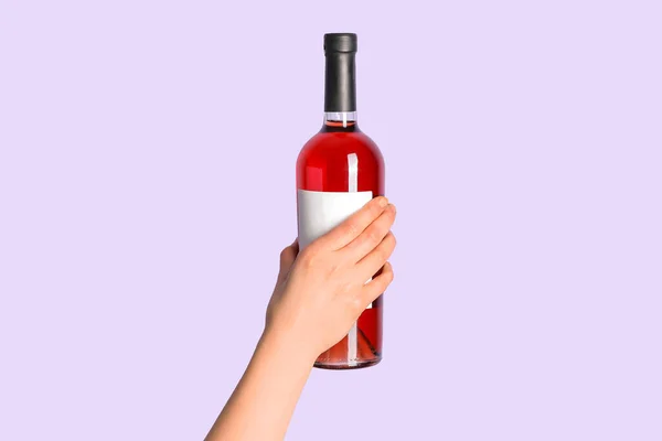Feminino Mão Segurando Garrafa Vinho Tinto Fundo Lilás — Fotografia de Stock