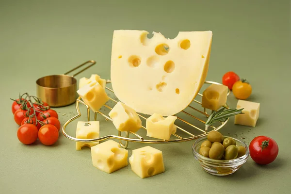 緑の背景にスイスチーズとオリーブの一片で立つ — ストック写真
