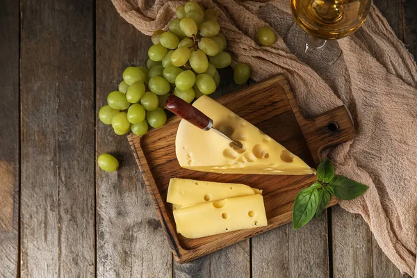 배경에 맛있는 스위스 치즈와 포도를 널빤지 — 스톡 사진