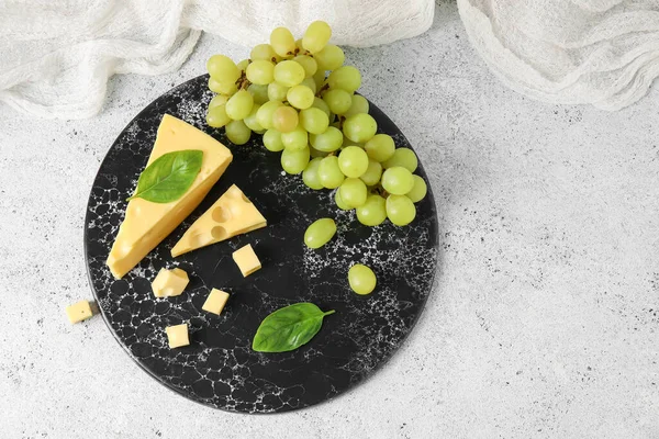 배경에 맛있는 스위스 치즈와 포도가 이사회 — 스톡 사진