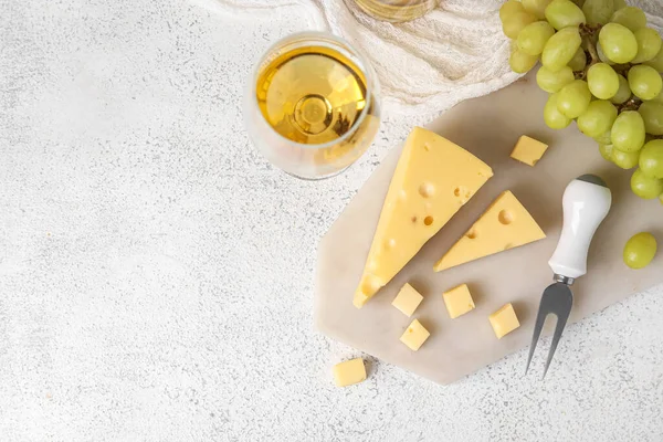 배경에 맛있는 스위스 치즈와 포도주 이차려진 이사회 — 스톡 사진