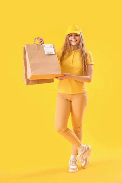 女性宅配便で紙袋付き黄色の背景 — ストック写真
