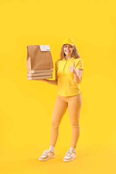 Female Courier Paper Bag Pizza Boxes Showing Thumb Yellow Background — Stock Photo, Image