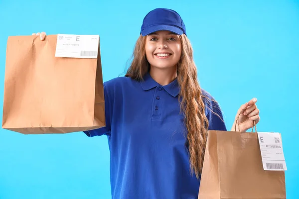 女性宅配便で紙バッグ上の青の背景 — ストック写真