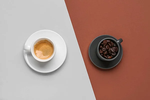 Stock image Cups of hot espresso and coffee beans on color background