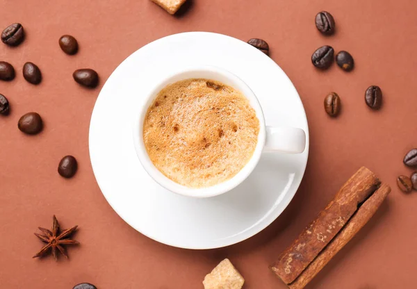 茶色の背景に熱いエスプレッソとコーヒー豆のカップ — ストック写真