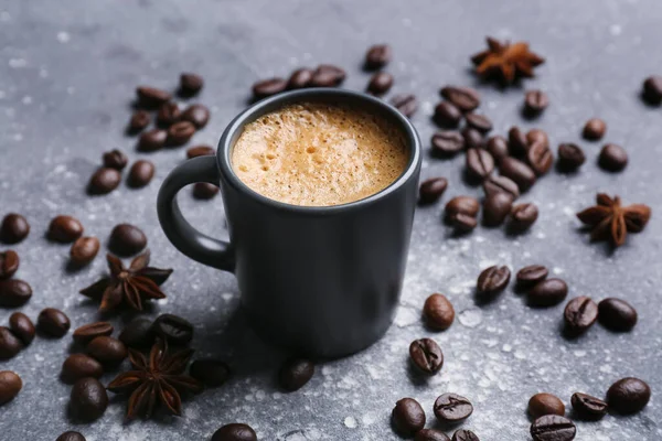 灰色の背景にホットエスプレッソとコーヒー豆のカップ — ストック写真