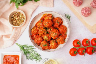 Bir kase leziz köfte ve açık arkaplanda sos.