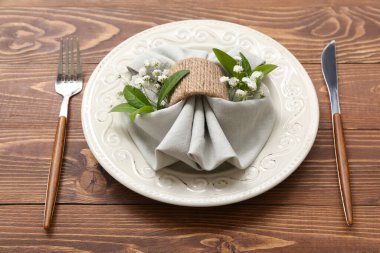 Tahta masa üzerinde çingene çiçekleri ve bitki yaprakları olan güzel bir masa.