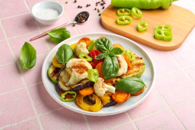 Pembe fayanslı ızgara sebze tabağı.