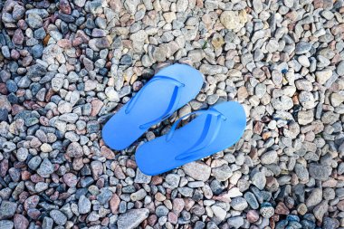 Kayalık sahilde mavi parmak arası terlikler
