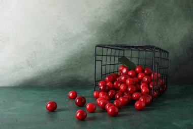 Yeşil masada kirazlı sepet.