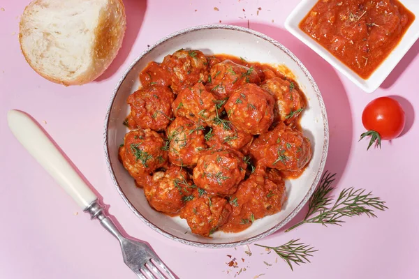 stock image Bowl of tasty meat balls with sauce on pink background