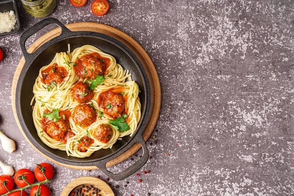 Stock image Frying pan of boiled pasta with tomato sauce and meat balls on grey table