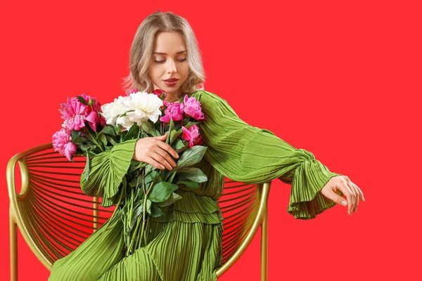 Ung Kvinna Med Vacker Pion Blommor Fåtölj Röd Bakgrund — Stockfoto