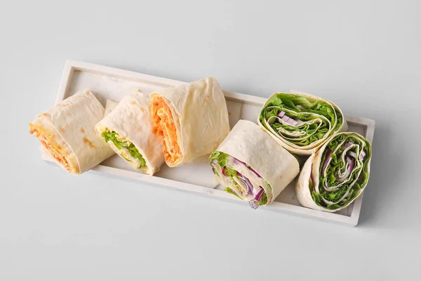 stock image Plate of tasty lavash rolls with vegetables on grey background