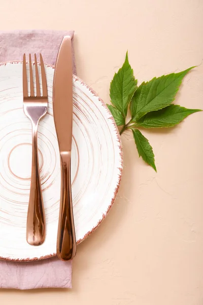 Schöne Tischdekoration Mit Sauberem Teller Besteck Und Grünen Pflanzenblättern Auf — Stockfoto