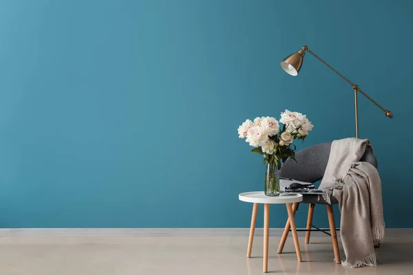 青い壁の近くのコーヒーテーブル 床ランプ付きの白い牡丹の花瓶 — ストック写真