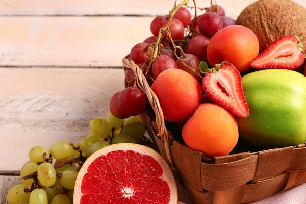 Rieten Mand Met Verschillende Verse Vruchten Witte Houten Ondergrond Close — Stockfoto