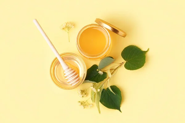 黄色の背景にリンデン蜂蜜とジャーとガラスボウル — ストック写真