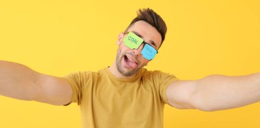 Sarı arka planda yapışkan notları olan gözlüklü suratsız adam. İş konsepti