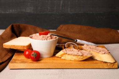 Bir kase lezzetli börek, sandviç ve domatesli açık ahşap masa.