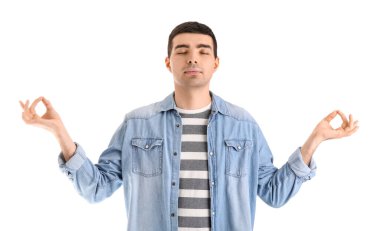 Genç adam beyaz arka plan üzerinde meditasyon yapıyor. Denge kavramı
