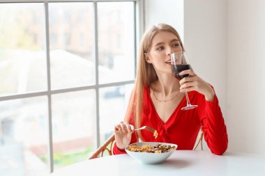 Lezzetli makarnalı genç bir kadın restoranda şarap içiyor.