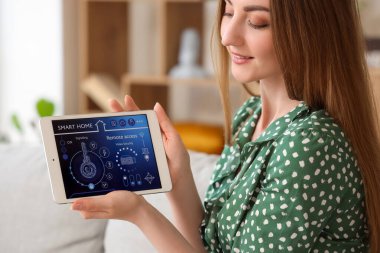 Akıllı ev güvenlik kontrol paneli olan genç kadın, yakın plan.