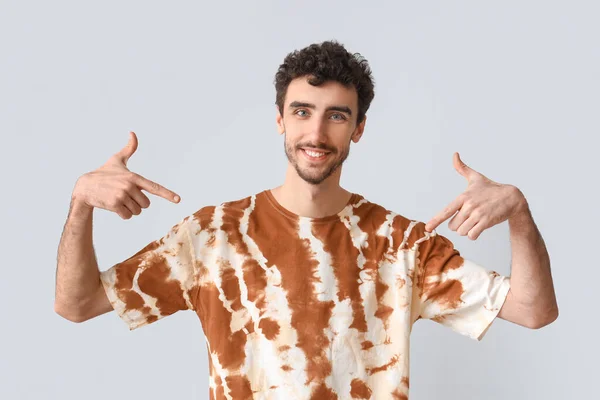 Bonito Homem Apontando Para Tie Dye Shirt Fundo Claro — Fotografia de Stock