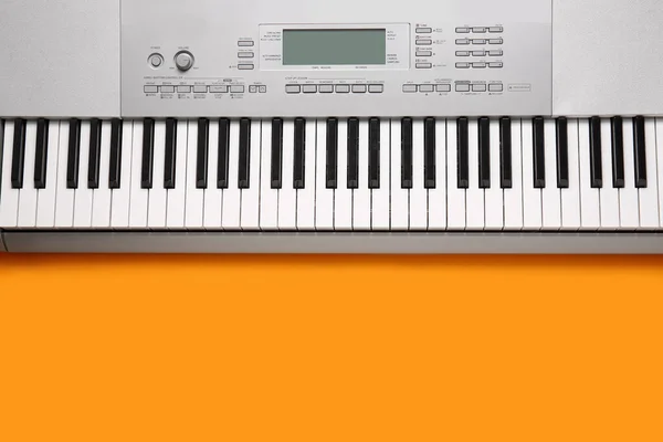 橙色背景的现代合成器键盘 — 图库照片