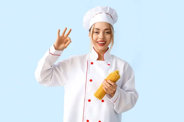 Femme Chef Avec Des Pâtes Crues Montrant Sur Fond Bleu — Photo