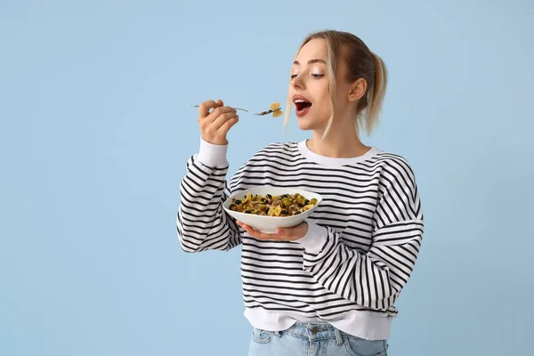 Junge Frau Isst Leckere Pasta Auf Blauem Hintergrund — Stockfoto